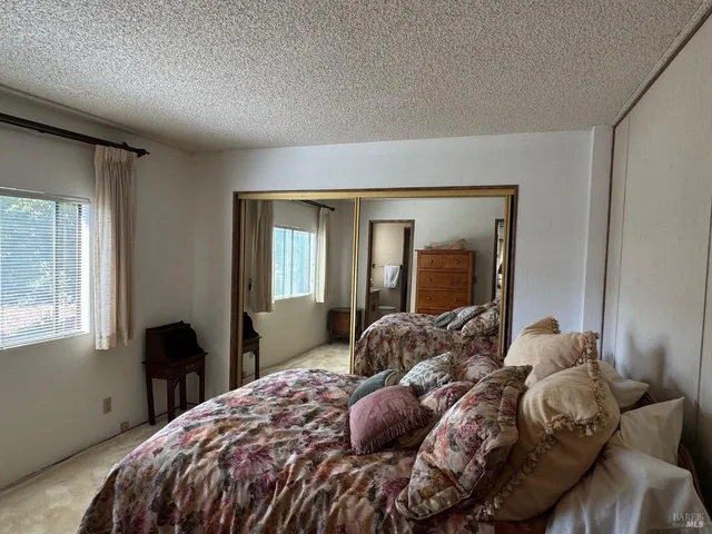 a bedroom with a large bed and windows