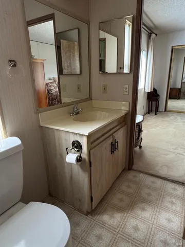 a bathroom with a sink a toilet and mirror