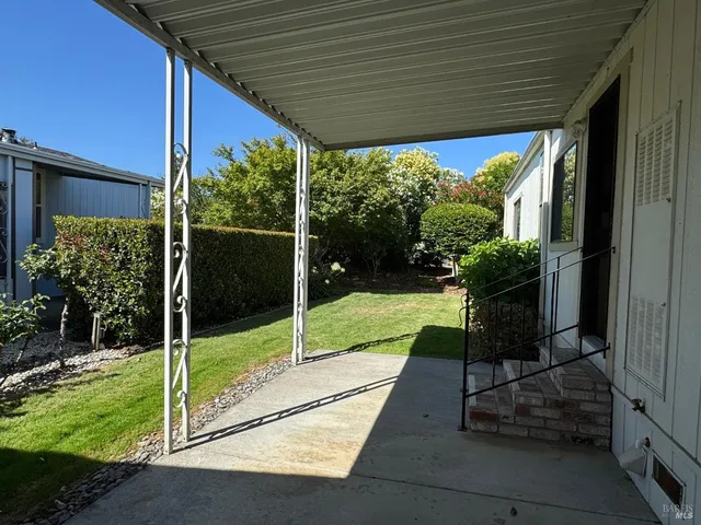 a view of a chair and table in backyard of the house