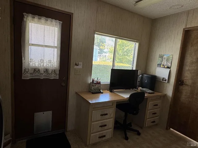a view of a workspace with furniture and a window