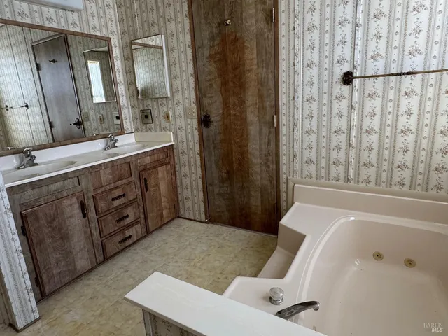 a bathroom with a tub sink and mirror