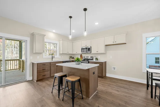 a kitchen with kitchen island granite countertop a sink a counter space appliances and cabinets
