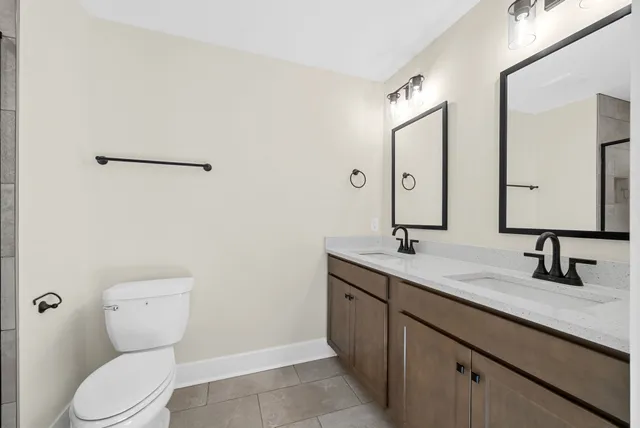 a bathroom with double sink and a mirror