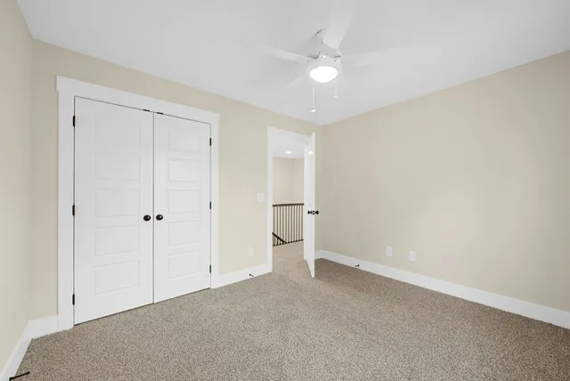 an empty room with a window and a ceiling fan