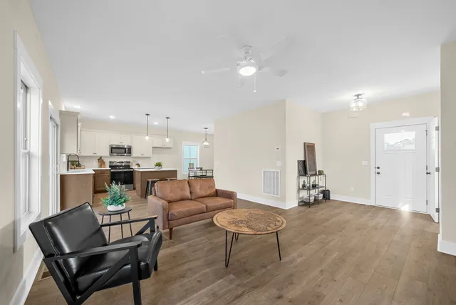 a living room with furniture and a view of kitchen