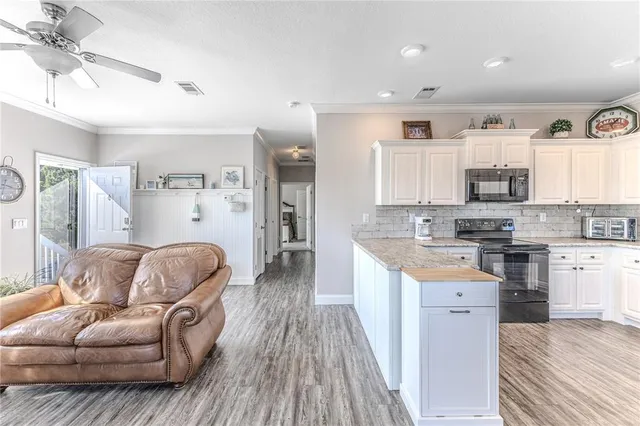 a kitchen with stainless steel appliances granite countertop a stove top oven a sink dishwasher a dining table and chairs