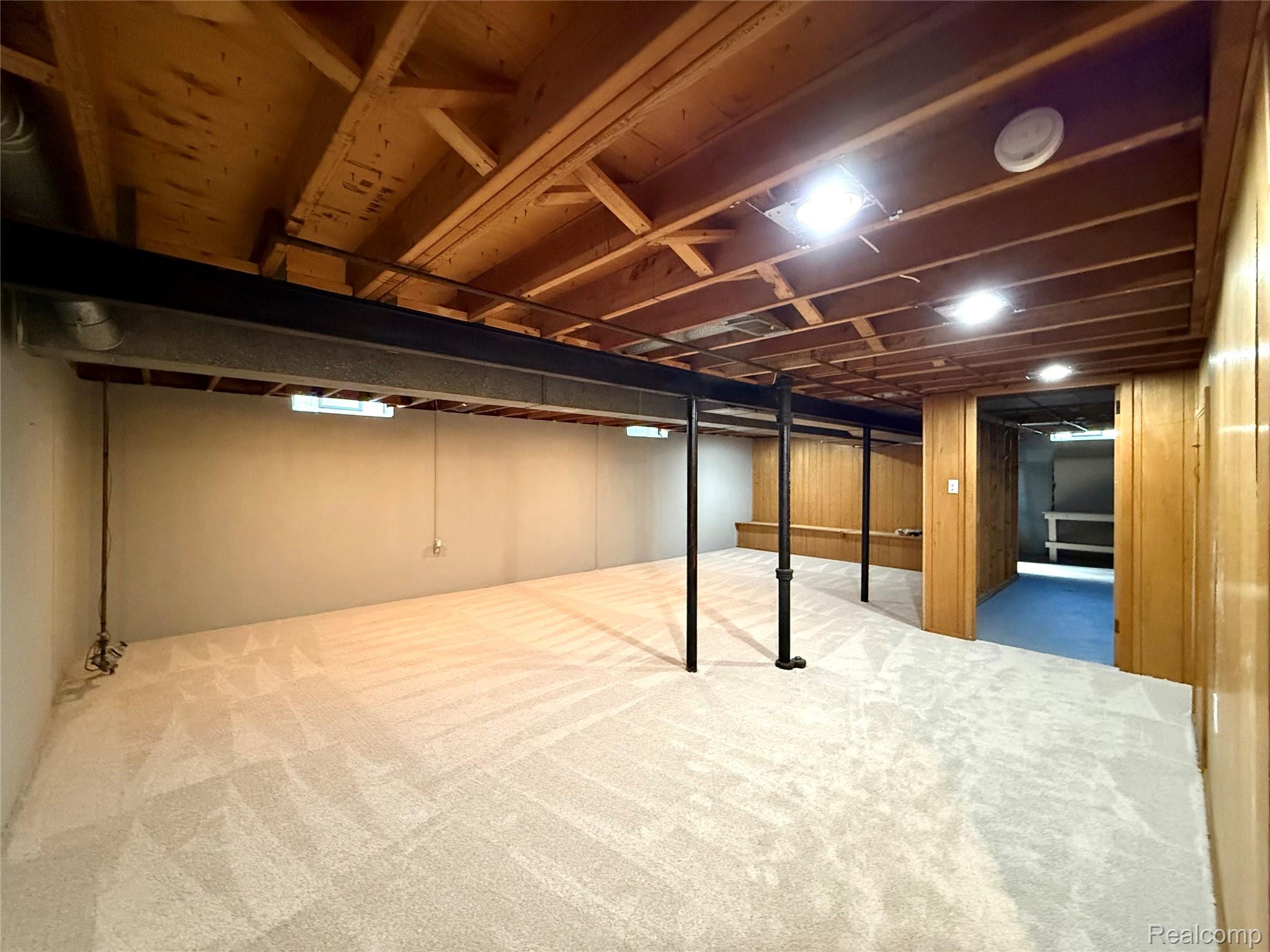 39909 Lynn Street Canton, MI 48187 - Photo 31 of 45 Spacious lower level featuring light-toned carpeting, wood paneling, exposed wood ceiling joists, and built-in bench seating