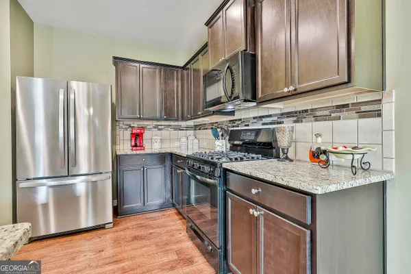 a kitchen with stainless steel appliances granite countertop a refrigerator stove and sink