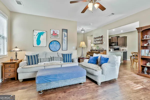 a living room with furniture a flat screen tv and a large window