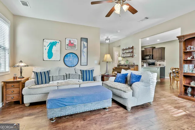 a living room with furniture a flat screen tv and a large window