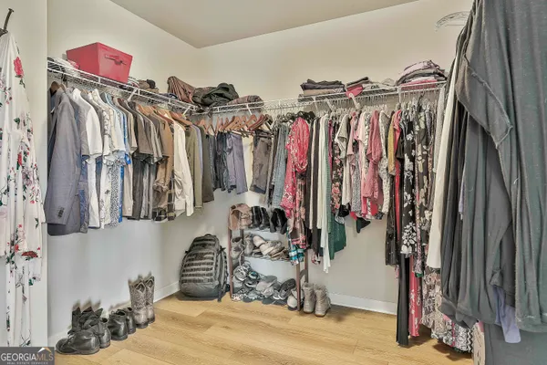 a view of walk in closet with clothes