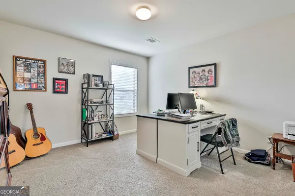a view of a workspace with furniture and a window