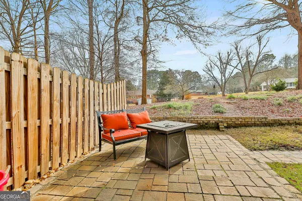 a view of a backyard with table and chairs with wooden fence and plants