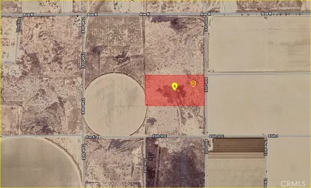 a view of a dry yard with mountains in the background