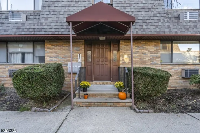 a view of an empty room with wooden floor and fan