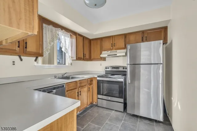 a kitchen with stainless steel appliances granite countertop white cabinets and a sink a window