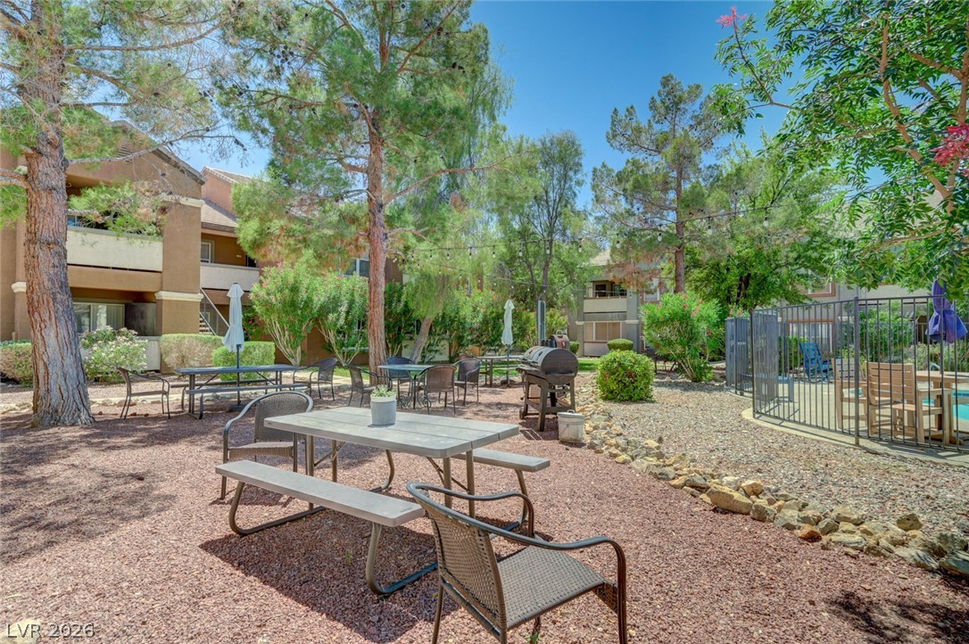 555 East Silverado Ranch Boulevard, Unit 2124 Las Vegas, NV 89183 - Photo 3 of 47 Gather around the barbecue in this inviting outdoor dining area, surrounded by lush trees and convenient amenities.