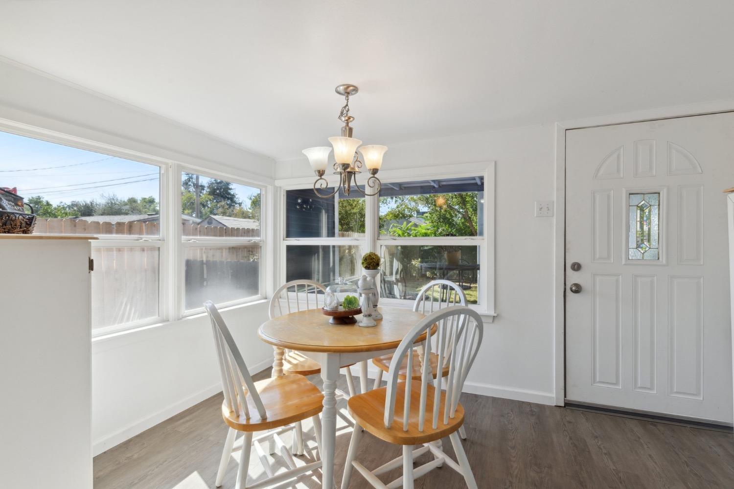 220 Sunnyside Avenue Clovis, CA 93612 - Photo 18 of 38 a dining room with furniture a chandelier and wooden floor