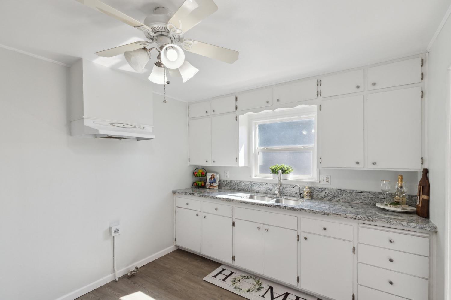 220 Sunnyside Avenue Clovis, CA 93612 - Photo 22 of 38 a kitchen with granite countertop a sink a window and cabinets