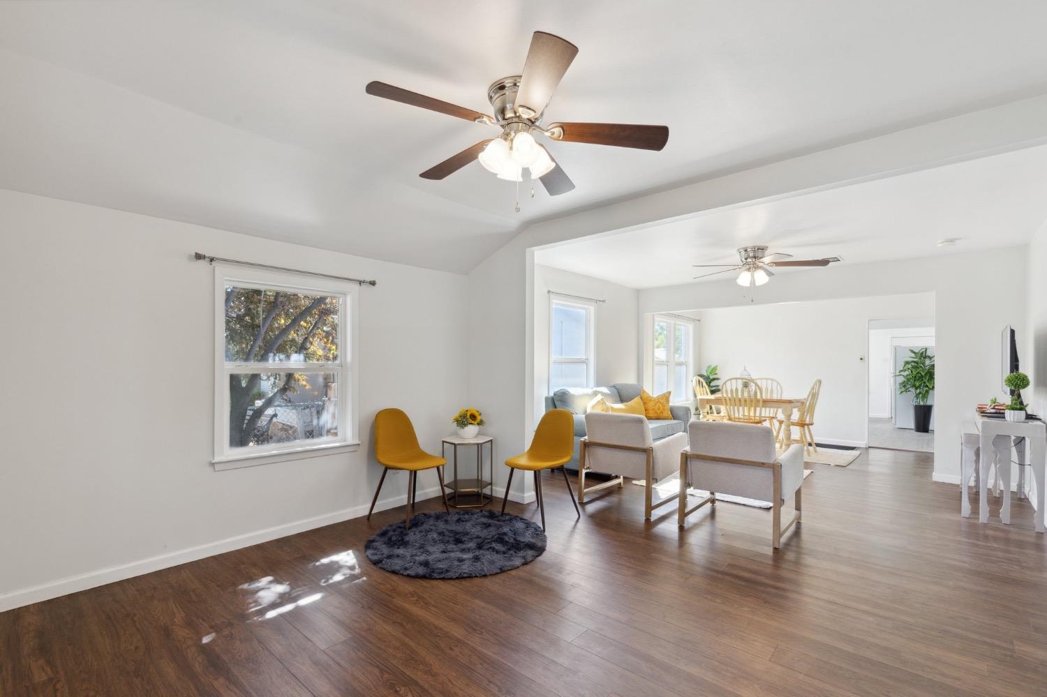 220 Sunnyside Avenue Clovis, CA 93612 - Photo 7 of 38 a dining room with wooden floor a chandelier fan a wooden table and chairs