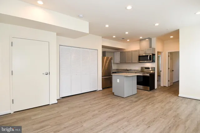 a kitchen with a refrigerator and a stove top oven