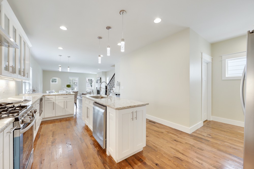 1332 B Lischey Avenue Nashville, TN 37207 - Photo 16 of 40 a kitchen with stainless steel appliances a white stove top oven a sink dishwasher and white cabinets with wooden floor