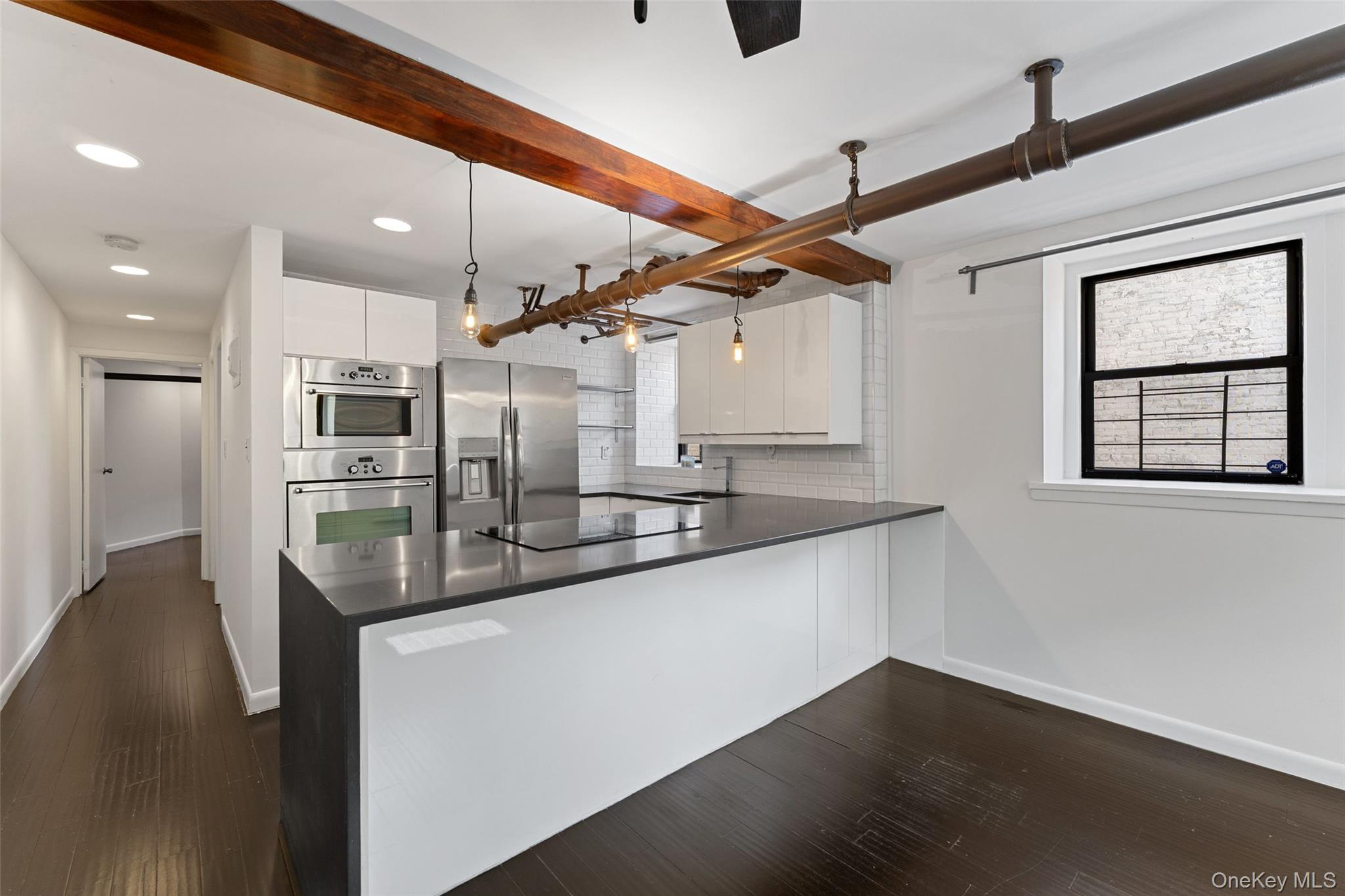 56 Pondfield Road West, Unit A Bronxville, NY 10708 - Photo 7 of 24 a large kitchen with stainless steel appliances kitchen island a large counter top and a wooden floors