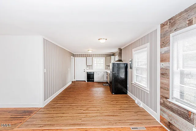 a view of a kitchen with refrigerator and wooden floor