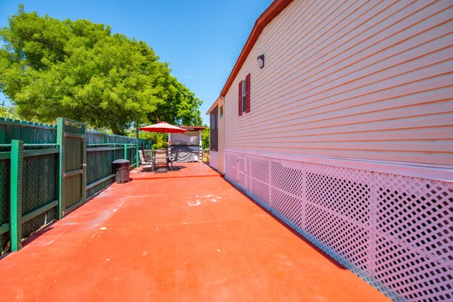 a view of a patio with table and chairs with wooden fence