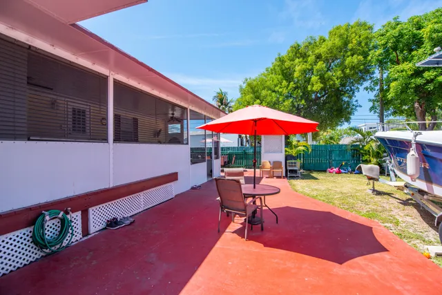 a patio with a table and chairs under an umbrella