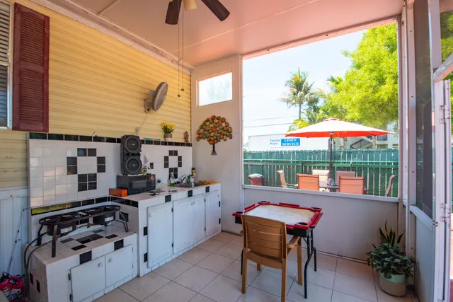 a backyard of a house with stainless steel appliances stove dining table and chairs