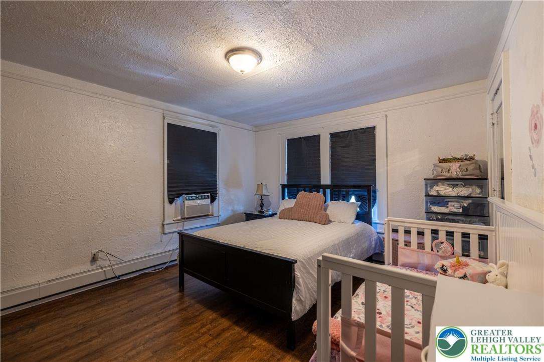 118 South 3rd Street Bangor, PA 18013 - Photo 17 of 33 This cozy bedroom features warm wood flooring and ample natural light, creating a comfortable retreat.