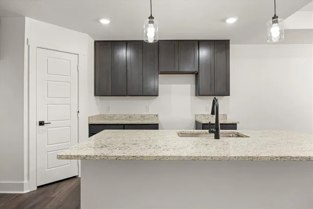 a kitchen with kitchen island granite countertop stainless steel appliances a sink refrigerator and microwave