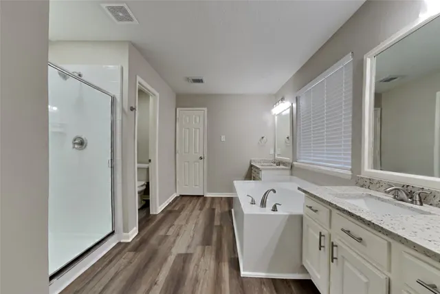 a spacious bathroom with a tub sink and mirror