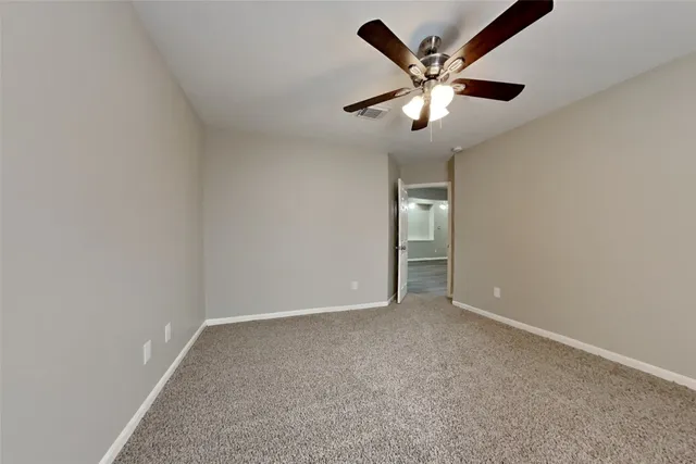 an empty room with closet and ceiling fan