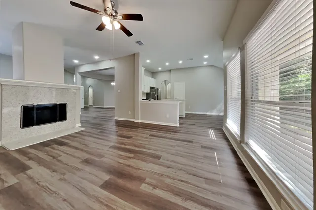 a view of a hallway with wooden floor and a kitchen