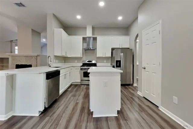 a kitchen with a refrigerator a sink and wooden cabinets