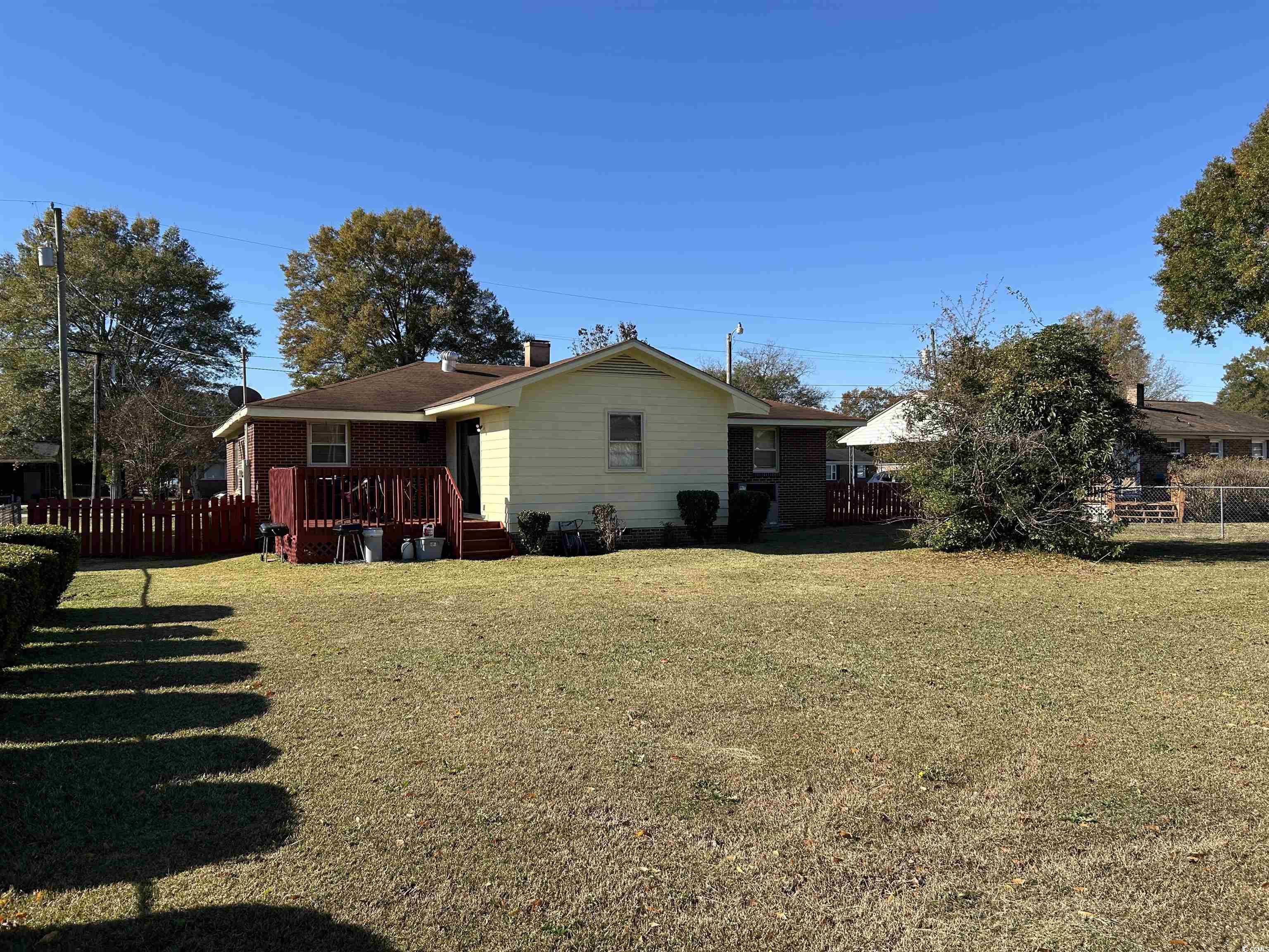 1411 East Harrison Street Dillon, SC 29536 - Photo 39 of 40 Back of property with a deck, a chimney, and brick siding