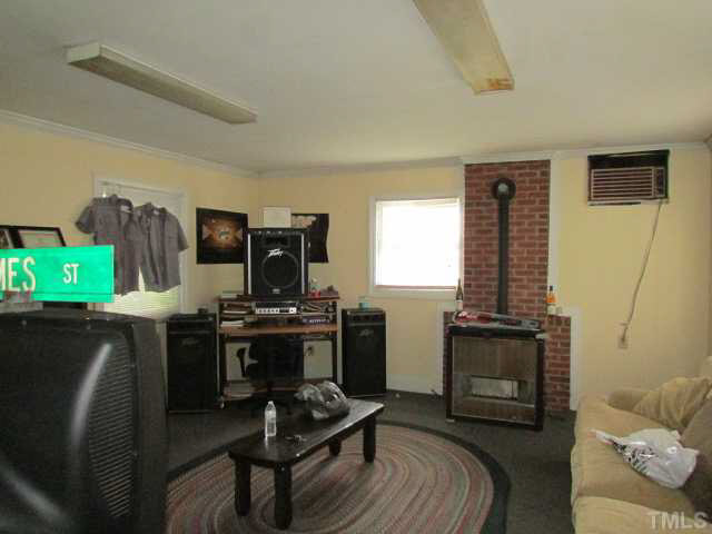 5111 Semora Road Roxboro, NC 27574 - Photo 22 of 25 a living room with furniture a fireplace and a flat screen tv