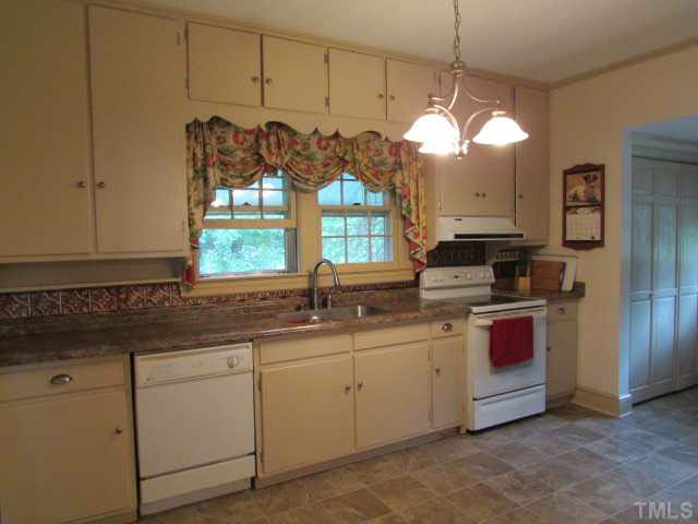 5111 Semora Road Roxboro, NC 27574 - Photo 4 of 25 a kitchen with stainless steel appliances granite countertop a sink a stove and a window