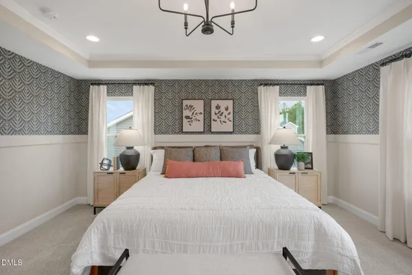 a bedroom with a large bed and a chandelier