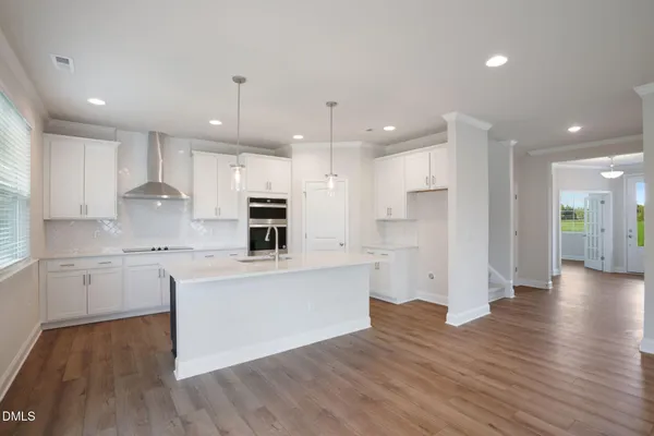 a large kitchen with cabinets wooden floor and stainless steel appliances