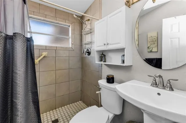 a bathroom with a sink toilet and shower