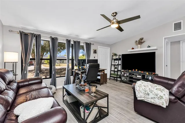 a living room with furniture a flat screen tv and a large window