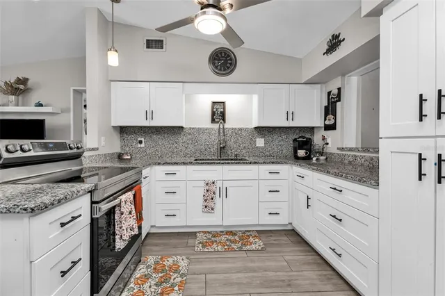 a kitchen with stainless steel appliances granite countertop a stove a sink and a granite counter tops