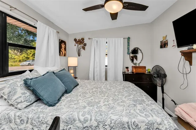a bedroom with a bed and a flat tv screen on dresser