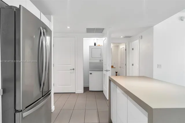 a view of a refrigerator in kitchen and white cabinets