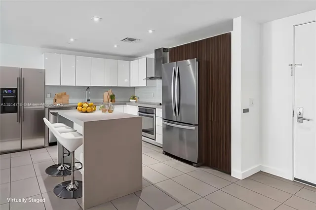 a kitchen with stainless steel appliances granite countertop a refrigerator and a stove top oven