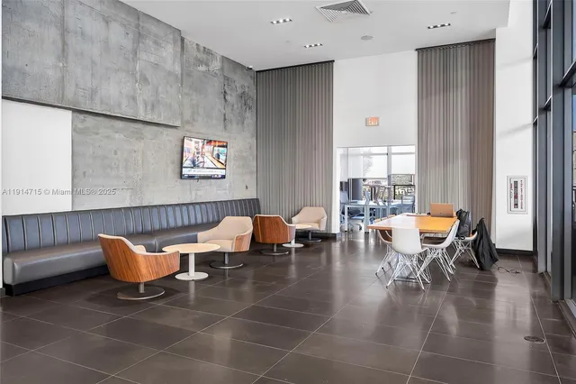a living room with couches and a dining table with garden view