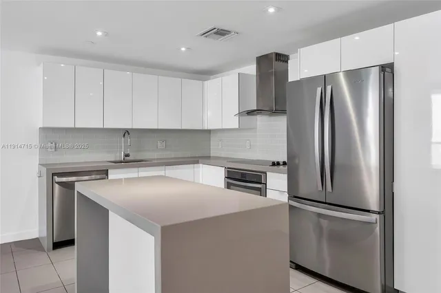 a kitchen with a refrigerator sink and cabinets